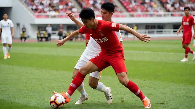 足球赛事比赛现场，球员在绿茵场上争抢球权的画面
