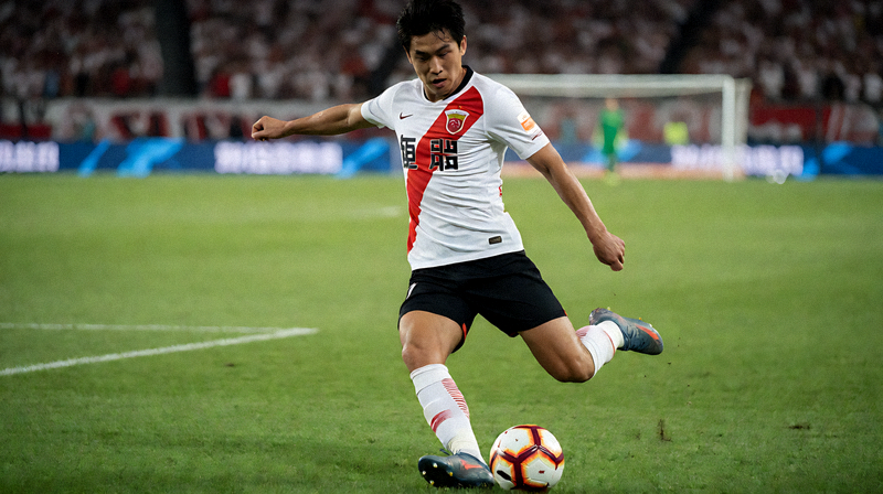 足球比赛中球员在草坪上传球组织的比赛画面